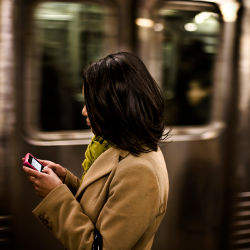 female in subway with cell phone