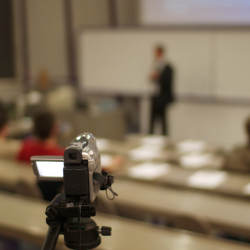 camera pointing to lecturer in classroom