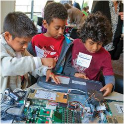 Elementary school students examine computer hardware