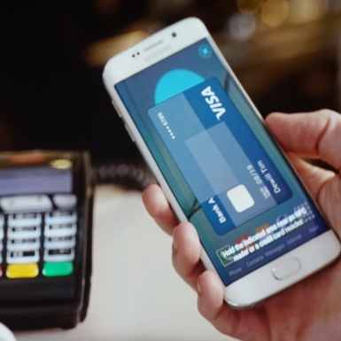 Using Samsung Pay at the point of sale, instead of a payment card.