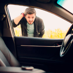 man peering into locked car