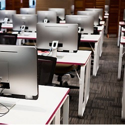 classroom desks with computer monitors