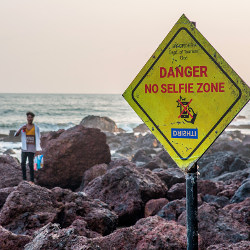 individual near 'Danger No Selfie Zone' sign