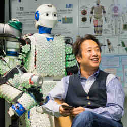 Roboticist Gordon Cheng and a robot draped with electronic skin developed by his research group.