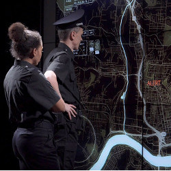police officers examine wall-sized map display