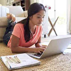 A girl using a laptop to complete her schoolwork.