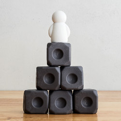 figure sitting on pyramid of blocks