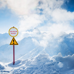 'Avalanche Danger' sign on snowy mountaintop