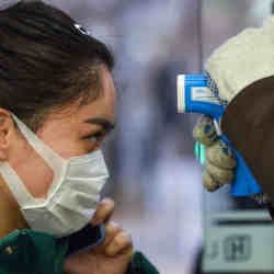 A woman having her temperature checked.