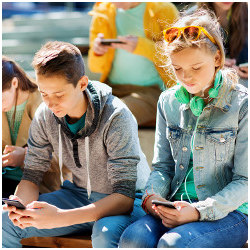 young male and female looking at smartphones