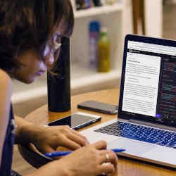 A coding student works remotely on a Codecademy course.