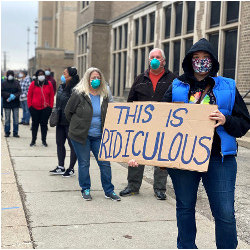 woman in line of voters holding 'This is Ridiculous' sign