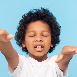 boy with eyes closed and arms extended