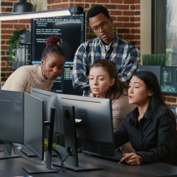group looking together at same computer displays