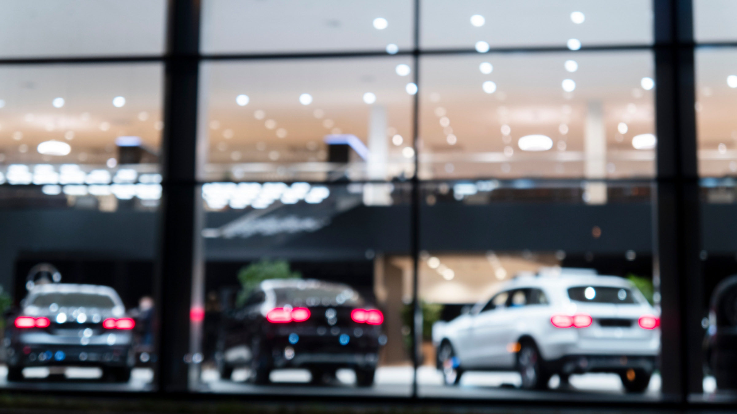 cars behind a large window at an auto dealership