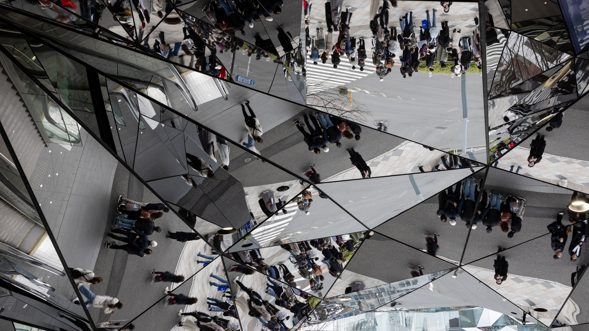 reflections of crowd on glass ceiling