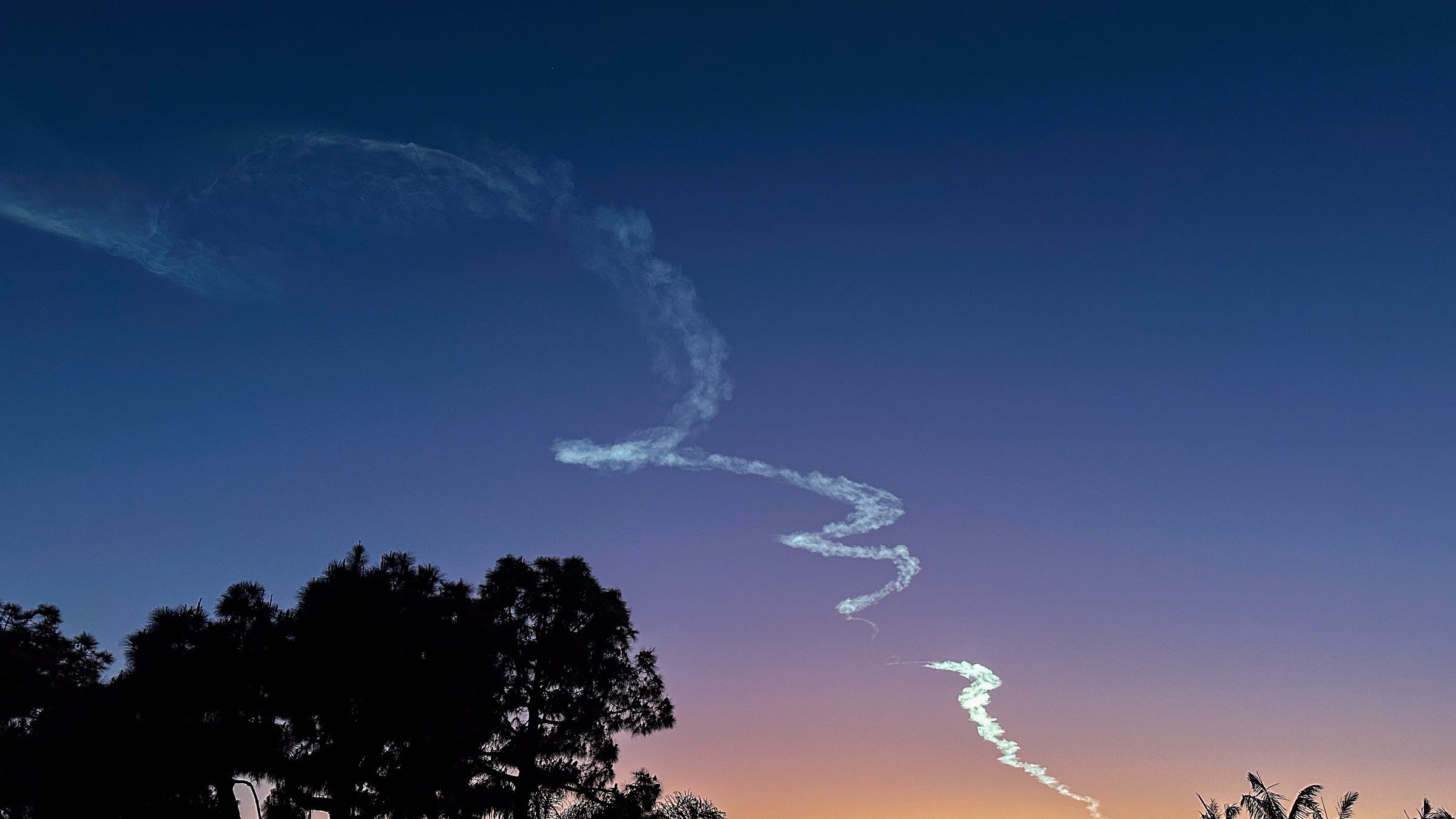 rocket contrails in deep blue sky