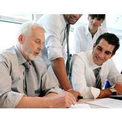 older worker with younger workers at a desk