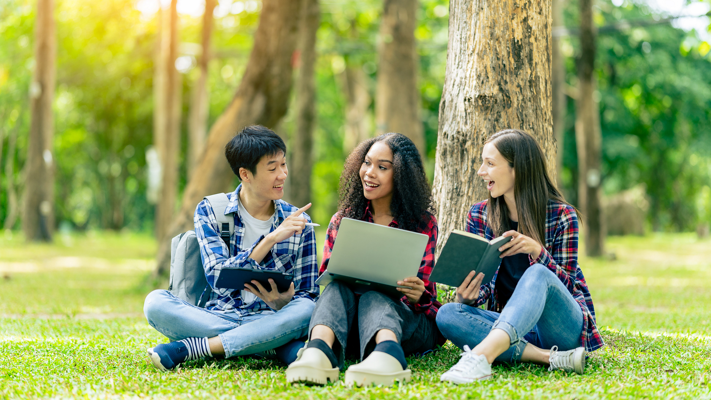 multiethnic college students with books and laptop computers